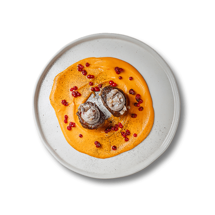 Plate of beef tenderloin paired with jack mackerels, garnished and served in a restaurant setting
